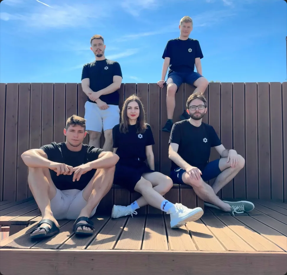 Four E2B teammates on a sunny rooftop deck